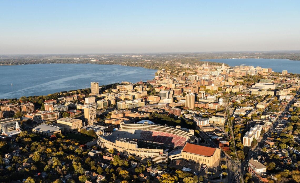 Aerial photo of The downtown Madison skyline and the University of Wisconsin-Madison campus, with Camp Randall Stadium in the foreground, along with Lake Mendota to the left and Lake Monona to the right are pictured in an aerial view during autumn on Oct. 13, 2016. The photograph was made from a helicopter looking east. (Photo by Jeff Miller/UW-Madison)