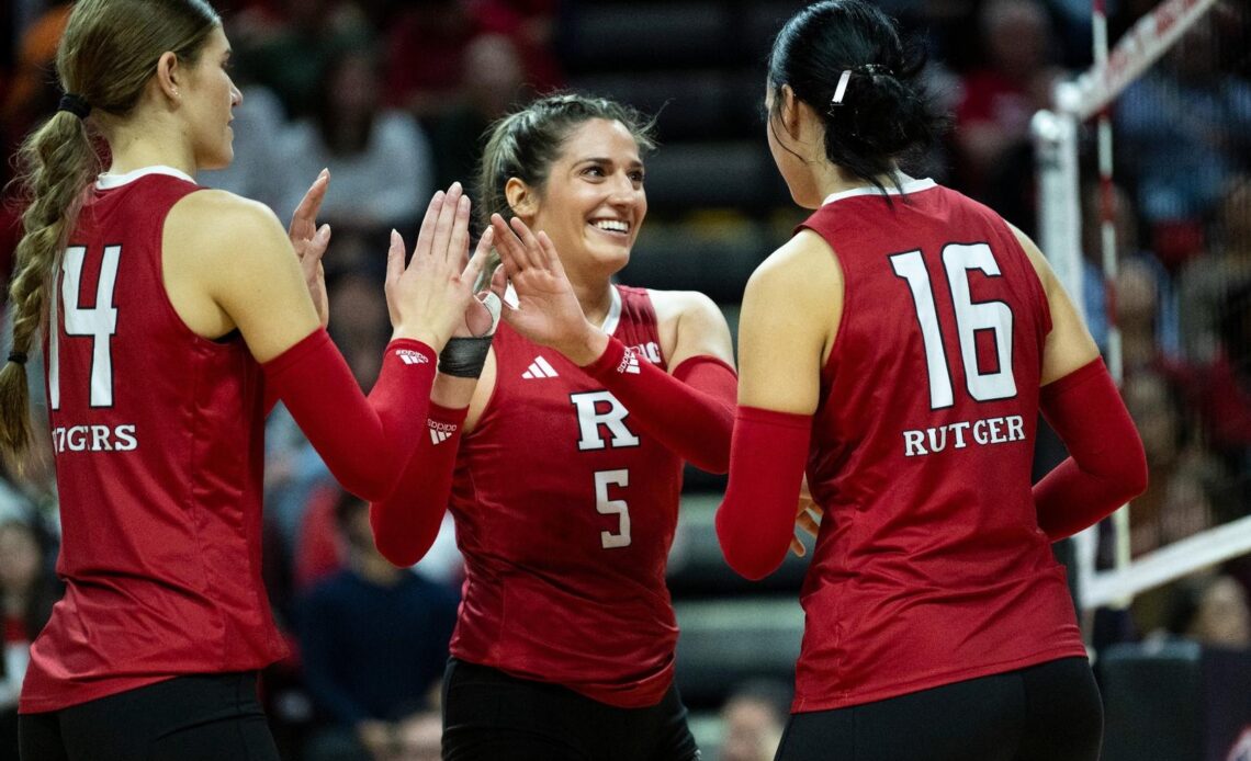 Alyssa Nayar high fives Anna Hartman & Kristina Grkovic during Rutgers' match with No. 1 Nebraska at Jersey Mike's Arena